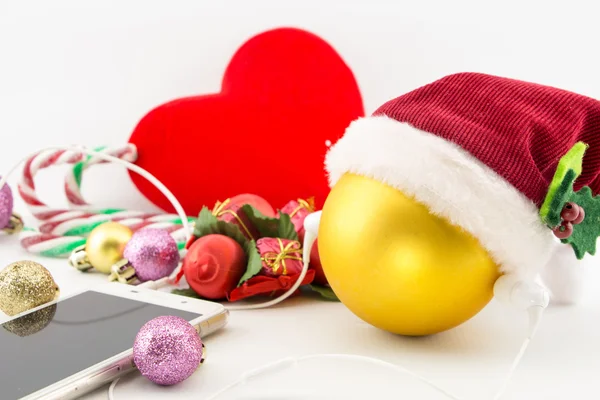 Christmas ball with Santa's hat and earphones with ornaments on white — Stock Photo, Image