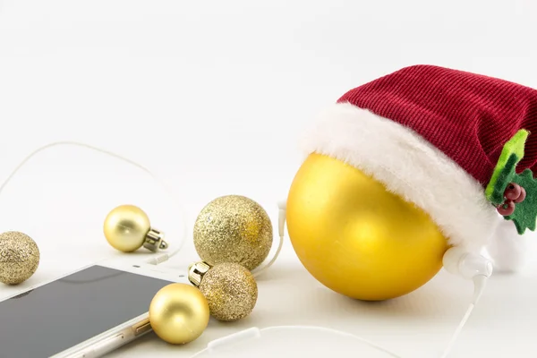 Bola de Navidad con sombrero de Santa Claus y smartphone con auriculares, aislada en blanco con espacio para copiar — Foto de Stock