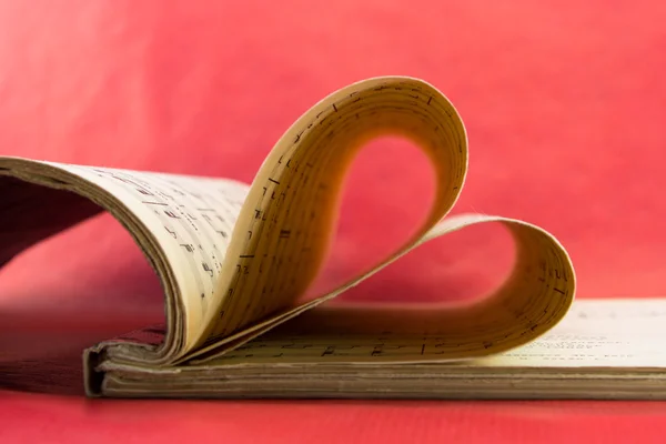 Music notation book with pages shaping heart closeup — Stock Photo, Image