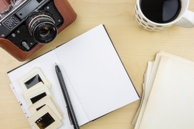 Ahşap yüzey üzerinde eski fotoğraf makinesi, defter, kalem ve şeffaflık slayt