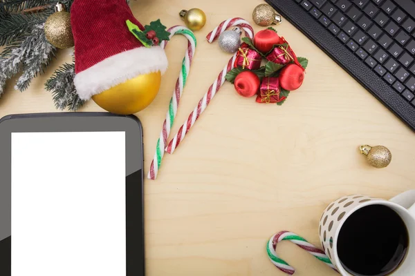 Tablet und Kaffeetasse mit winterlichem Festschmuck. — Stockfoto