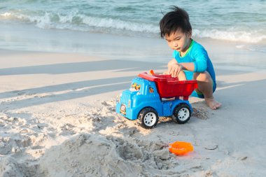 Bir kumsalda oynarken genç Tay çocuk