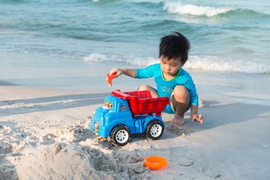 Bir kumsalda oynarken genç Tay çocuk