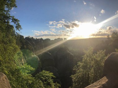 Saxon İsviçre 'deki Koenigstein yakınlarındaki Bastei Köprüsü' nde gün doğumu yürüyüşçülerin patikasına yakın.