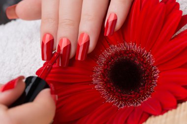 Kadınsı kırmızı ve turuncu tırnaklar