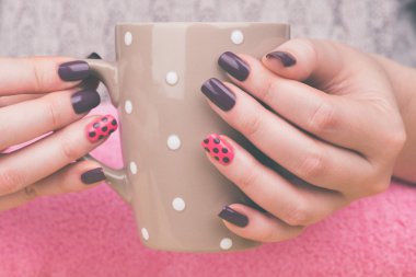 Cup in manicured female hands clipart
