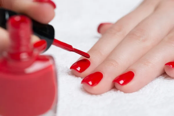 woman's hands with red nail polish