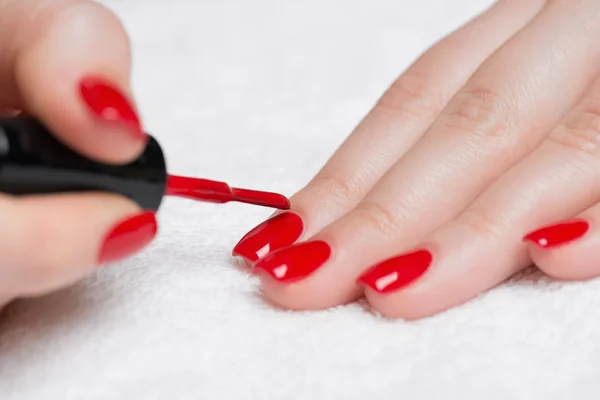 woman's hands with red nail polish