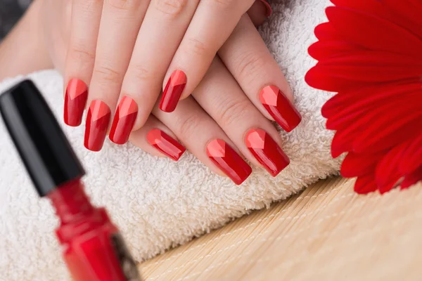 Unhas vermelhas e laranja femininas — Fotografia de Stock