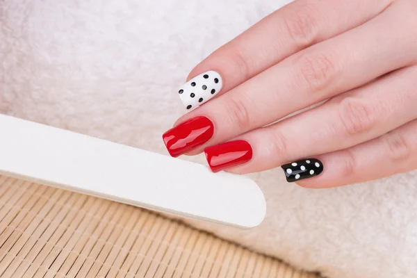 Unhas com verniz vermelho, branco e preto — Fotografia de Stock