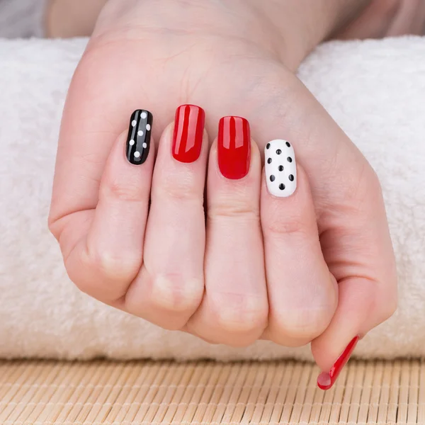 Unhas com verniz vermelho, branco e preto — Fotografia de Stock