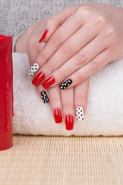 Fingernails with red, white and black polish