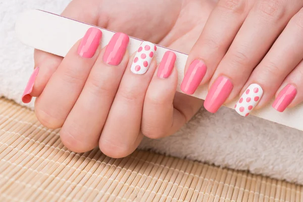 Unhas com esmalte rosa e branco — Fotografia de Stock