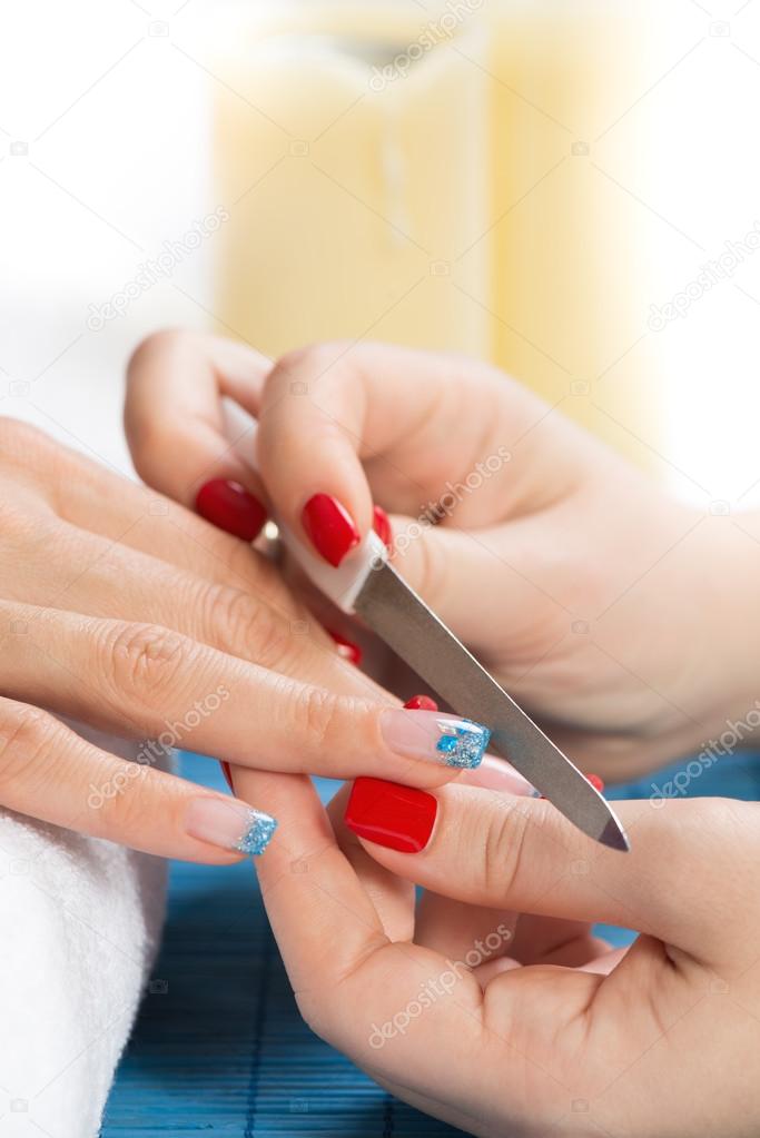 Woman having manicure treatment in salon