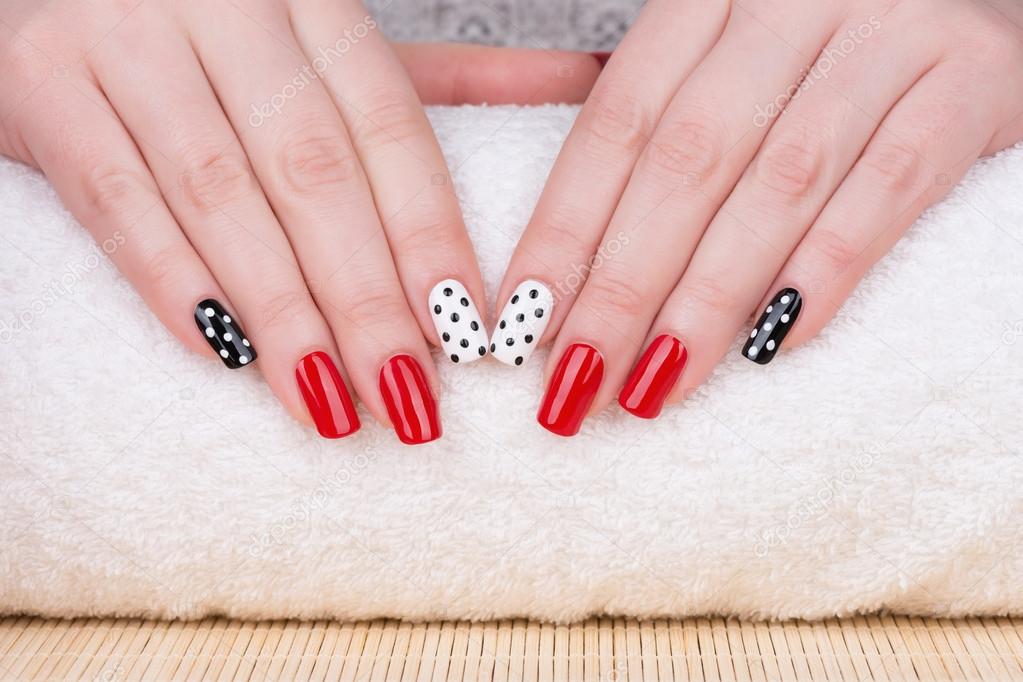 Fingernails with red, white and black polish