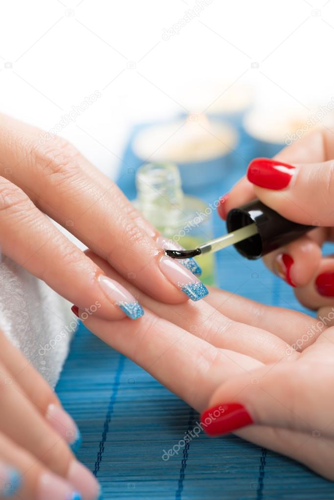 Beautician applying cuticle oil