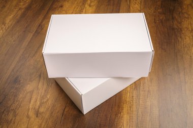 Boş beyaz kutu ahşap arka plan üzerinde sahte kadar