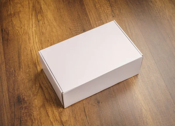 Blank white box mock up on wood background — Stock Photo, Image