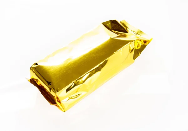 Пакет из золотой фольги на белом фоне — стоковое фото