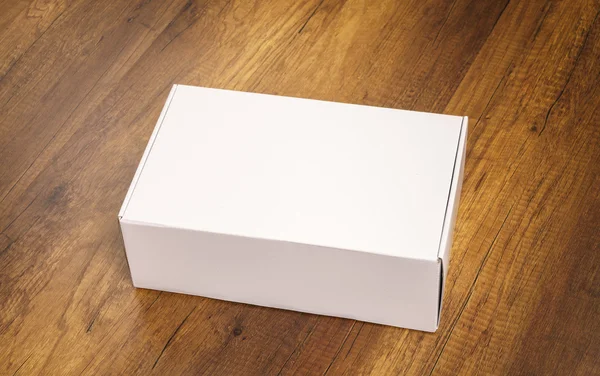 Blank white box mock up on wood background — Stock Photo, Image