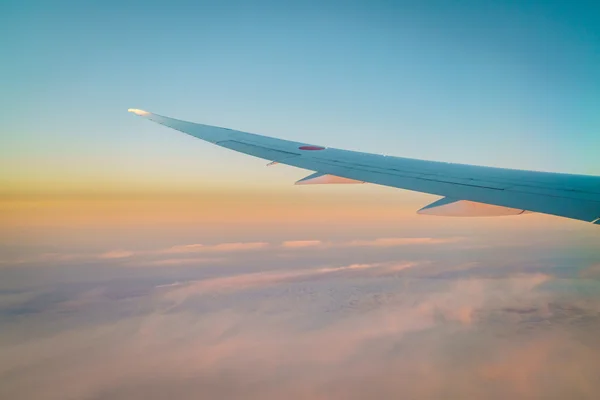 Vinge på ett flygplan som flyger ovanför molnen — Stockfoto