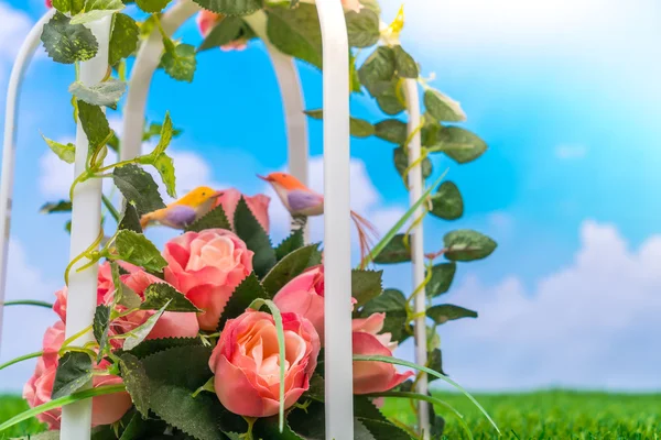 Artificial flowers on grass — Stock Photo, Image