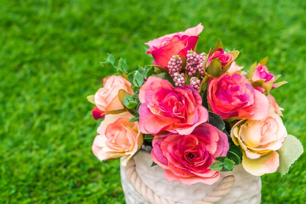 Künstliche Blumen auf Gras — Stockfoto