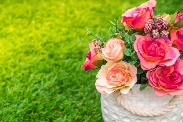 Artificial flowers on grass — Stock Photo, Image