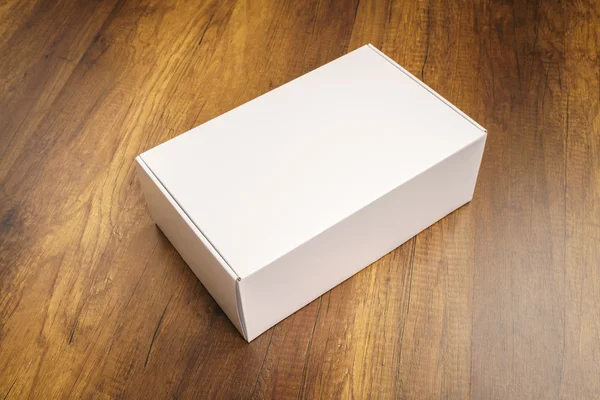 Boş beyaz kutu ahşap arka plan üzerinde sahte kadar