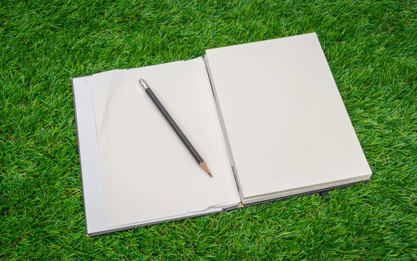 Cuaderno sobre hierba verde primavera — Foto de Stock