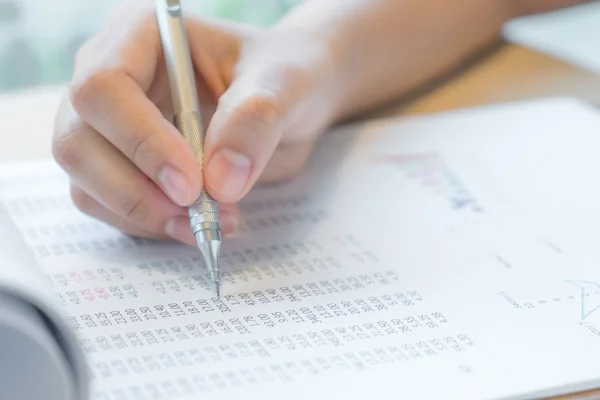 Mão escrever em vários gráficos financeiros na tabela — Fotografia de Stock