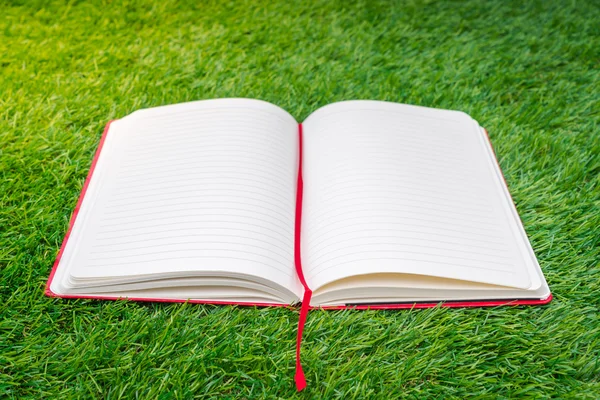 Notebook on spring green grass — Stock Photo, Image