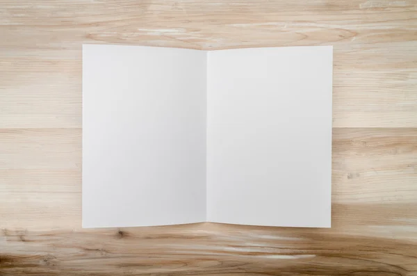 Біфолд білий шаблонний папір на текстурі дерева — стокове фото