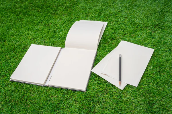 Notebook na zelené trávě — Stock fotografie