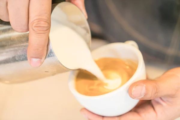 Milch gießen, um Latte-Kaffee-Kunst zu mischen — Stockfoto