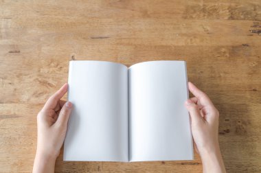 Elleri boş katalog, dergi, kitap sahte ahşap masa üzerinde aç kapıyı 