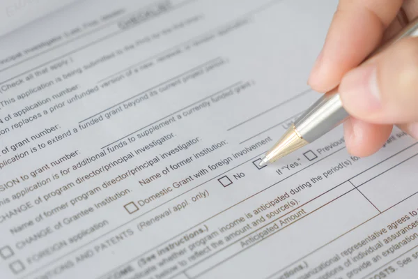 Hand with pen over application form — Stock Photo, Image