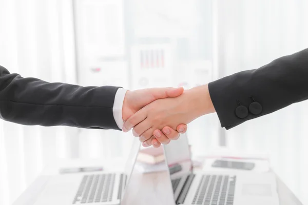 Business people shaking hands over laptop — Stock Photo, Image