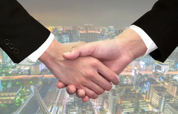 Business handshake over cityscape — Stock Photo, Image