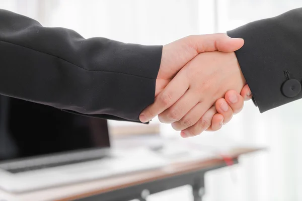 Business people shaking hands over laptop — Stock Photo, Image