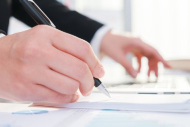 Laptop üzerinde dikkat çeken bir kalem kullanarak iş adamları 