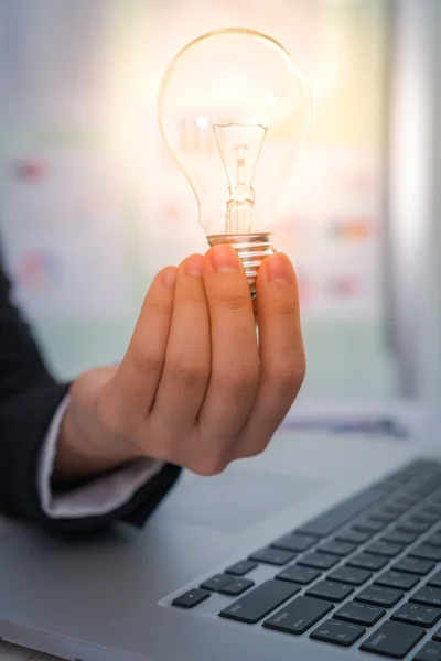 Business man holding light bulb — Stock Photo, Image