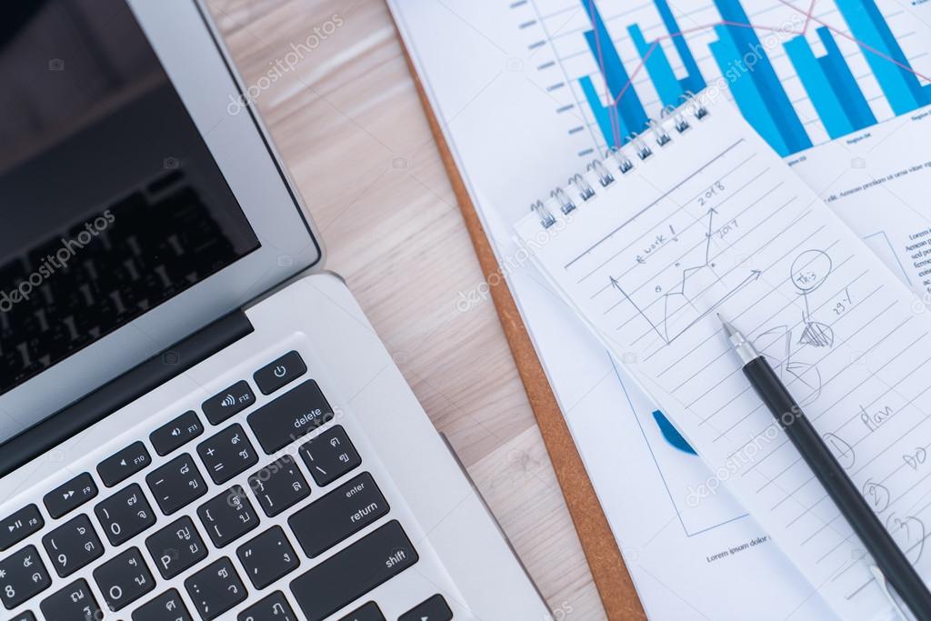 Financial charts on the table with lapto