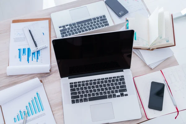 Financial charts on the table with laptop and mobile phon — Stock Photo, Image