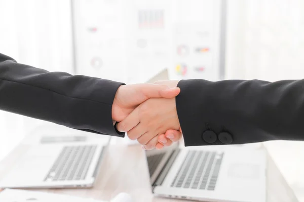 Business people shaking hands over laptop — Stock Photo, Image