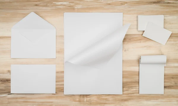 Envelopes em branco, cartão de nome e papel de modelo branco em ba de madeira — Fotografia de Stock