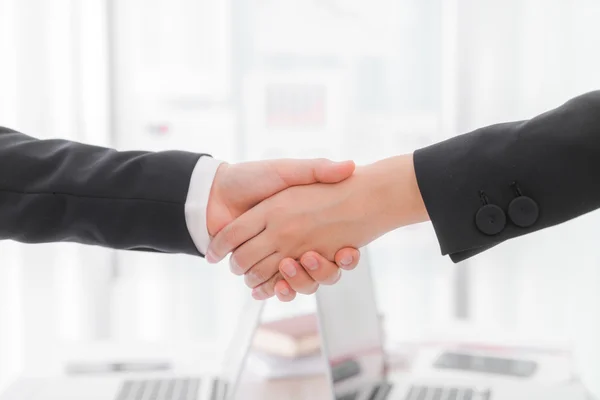 Business people shaking hands over laptop — Stock Photo, Image