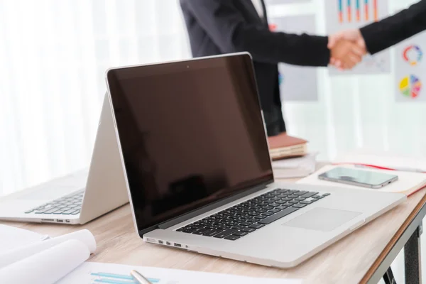 Business people shaking hands over laptop — Stock Photo, Image