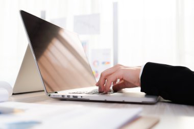 Laptop klavyesinde yazan kişi