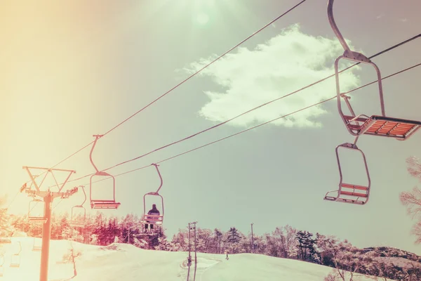 Pôr do sol e elevador de esqui passando sobre a montanha (imagem filtrada pr — Fotografia de Stock